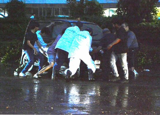 水没した車を押す警察官ら＝３日午後７時20分、宇都宮市下岡本町