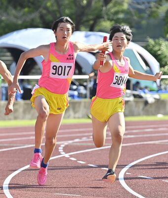 男子４００メートルリレー決勝　大田原の糸数（右）がアンカーの室井にバトンをつなぐ＝佐野市の清酒開華スタジアム