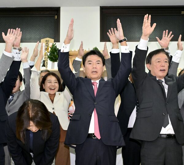 6選を確実にし、万歳する佐藤栄一氏(中央)=17日午後7時15分、宇都宮市不動前1丁目、河野光吉撮影