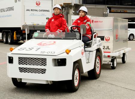 　駐機場で貨物けん引車を運転するミャンマー国籍のテッ・ウェー・フウさん（右）＝２１日午後、成田空港