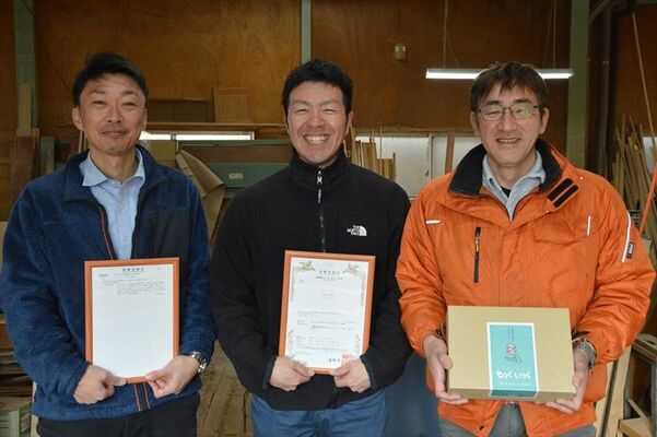商標登録証を持つ（左から）東海林さん、為永さんと、「もっくいっく」を持つ古内さん