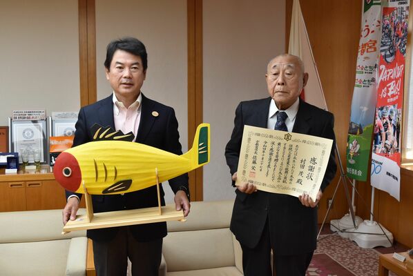 佐藤市長に黄ぶなを寄贈した村田さん（右）
