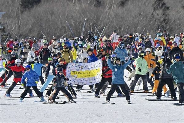 感謝の横断幕と共に最後の集団滑走をするスタッフや来場者ら＝10日午後２時30分、那須町大島