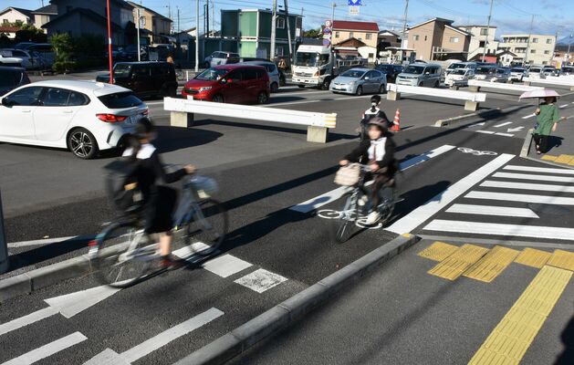 LRT延伸でさらなる拡幅が計画されている県道。整備中の工区は車道部分にガードレールが並び、歩道との間には自転車道が設けられている=28日午前、宇都宮市桜4丁目