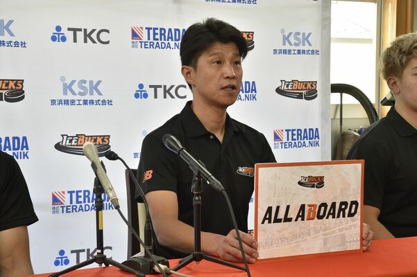 今季の新体制発表会見でスローガン「ＡＬＬ　ＡＢＯＡＲＤ」を発表する藤澤監督＝７月３日、日光市のクラブ事務所