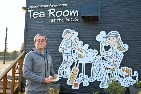 おすすめのミートパイを持ってカフェの前に立つ宮地さん