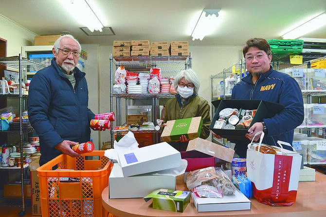 牧岡事務局長（右）と寄贈された食品の仕分けを行うボランティアの室町一江さん（中央）、広沢敬行さん