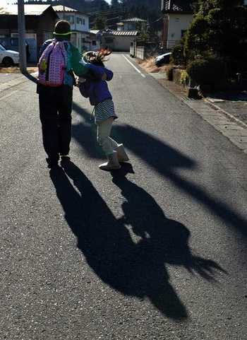 はしゃぐ妹のリュックを兄が背負う。２人が向かう先は、生活の苦しい子らを支援する居場所＝１２月２５日、日光市内