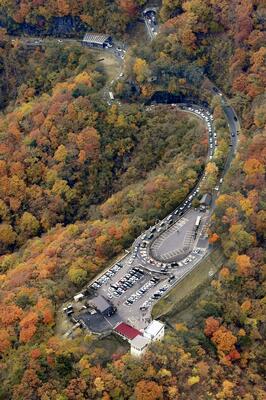 県がいろは坂の渋滞対策として閉鎖した明智平の県営駐車場(手前右)。午前中は一定の効果があったが、午後には激しい渋滞が発生した=2日午後1時19分(共同通信社ヘリから)