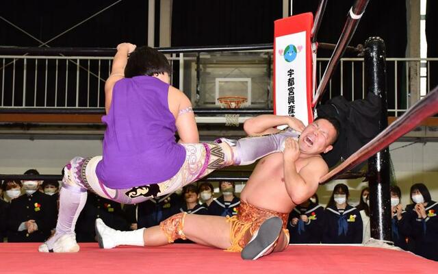 立志式で行われたプロレスの試合。攻撃に耐える朱鷺選手（右）