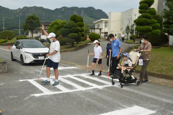 車両接近通報音を聞き分けながら横断体験をする生徒たち