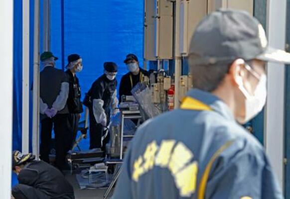 　姫野忠文容疑者の自宅周辺を調べる大分県警の捜査員＝１２日午前９時５９分、大分市