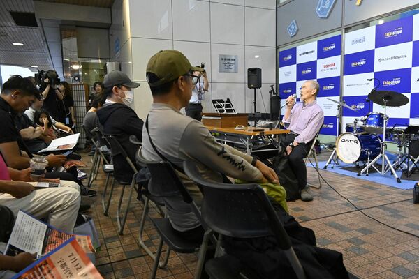 ピースうつのみやが歩んだ40年の歴史を語る田中代表（右）＝12日夕方、宇都宮市駅前通り１丁目