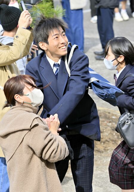 合格発表で自分の番号を見つけ喜ぶ受験生ら＝12日午前10時、宇都宮市元今泉８丁目