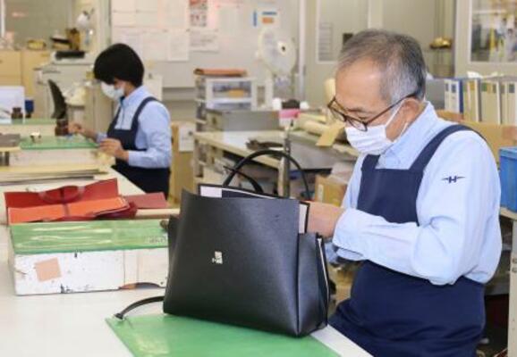 「グレースディライトトート」を手作業で仕立てる職人=4日、長野県御代田町