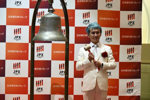 上場を祝う鐘の横に立つ森下社長＝１０日午前、東京都内