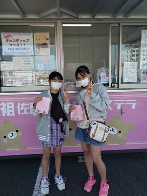 ベビーカステラを手に笑顔を見せる児童たち
