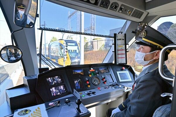 鏡を見て乗降客の安全を確認する武井さん＝27日午前８時45分、宇都宮市清原工業団地