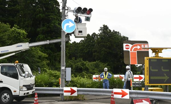 黒磯板室ICのランプ線に右折用矢印と標識を設置する業者ら=日午前、那須塩原市鹿野崎