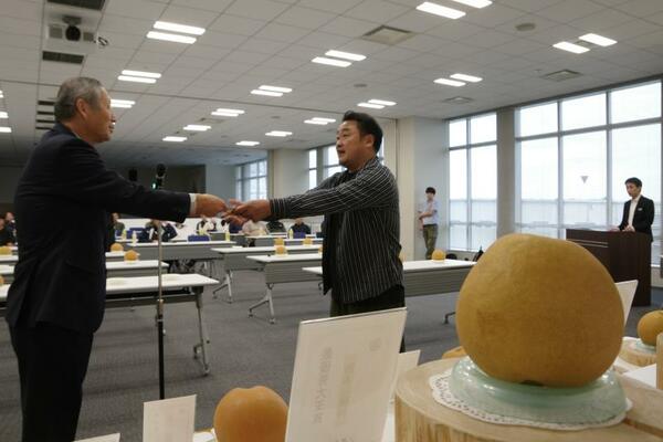 賞状を受け取る鈴木さん（左から２人目）と、鈴木さんが育てたナシ（右）＝29日午後、宇都宮市
