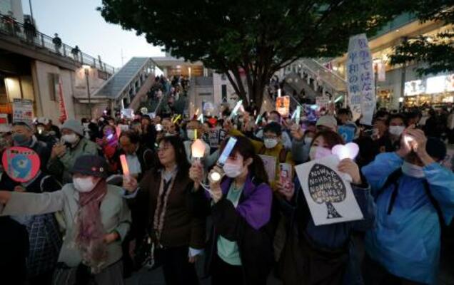 東京・新宿駅前で憲法9条改正反対を訴える集会に参加する人たち=16日夕