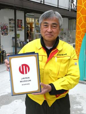 文化庁から授与された登録博物館のマークを掲げ、構想を語る荒井園長＝６日午後、宇都宮市上金井町の宇都宮動物園