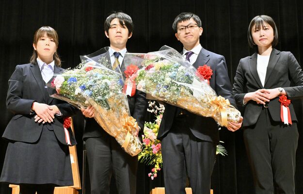 花束を手にステージに立つ藤井王将（左から２人目）と永瀬九段（同３人目）＝７日午後６時10分、大田原市堀之内