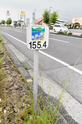 愛媛県四国中央市の国道11号バイパスに設置されている１００メートル間隔のプレート型の距離標（キロポスト）＝４月30日、同市中曽根町（車のナンバープレートを画像加工しています）