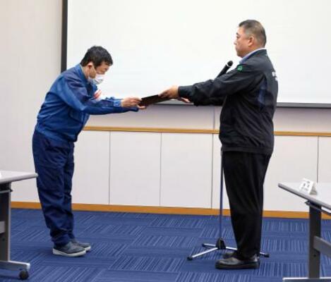 　原子力規制委側から「使用前確認証」を受け取る東京電力柏崎刈羽原発の稲垣所長（左）＝１６日午後、新潟県刈羽村