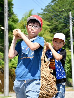 「もっこかつぎ」を体験する児童