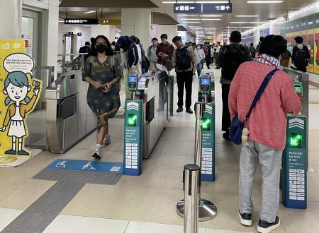 一部区間で完成したMRTの自動改札を通る筆者(右)=JICA提供