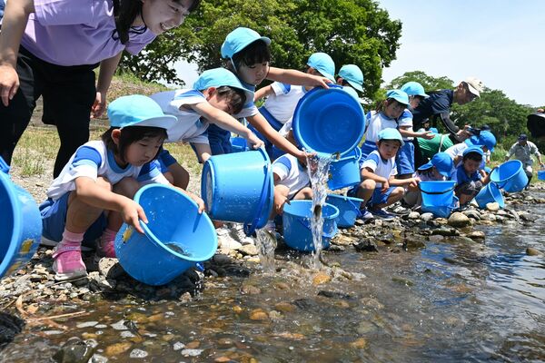 那珂川に稚アユを放流する園児