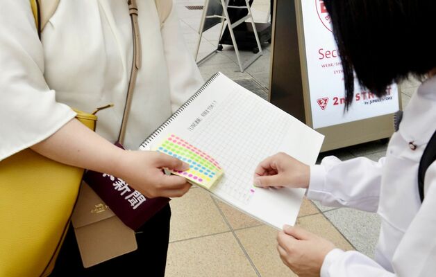 「ＬＩＮＥ何時までＯＫ？」のアンケートに答える通行人＝５月２３日、鹿児島市東千石町