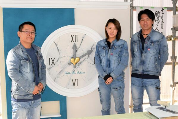 自由課題で表現した「時計」の前に立つ阿久津社長、遅澤さん、遠山さん（左から）