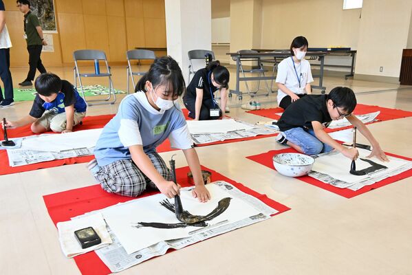 真剣に筆を振るう児童たち