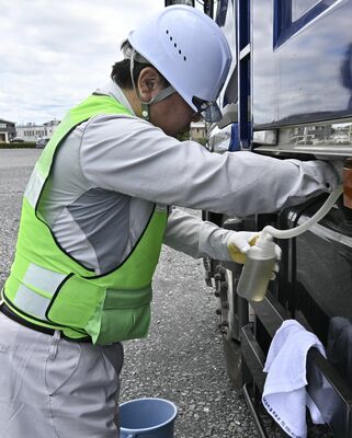 燃料タンクから軽油を抜き取る職員＝４日午前、真岡市田町