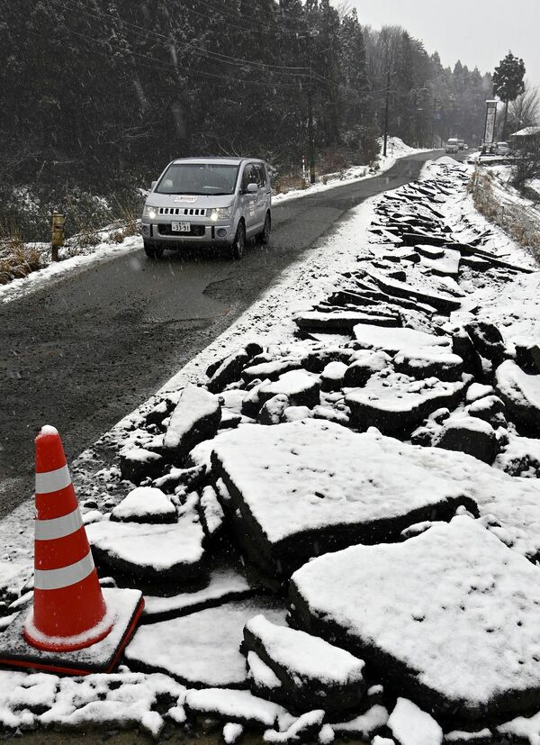 路面が崩壊し片側通行となった道路。各所でこうした被害があり、渋滞の原因となっている＝13日午前９時５分、石川県輪島市