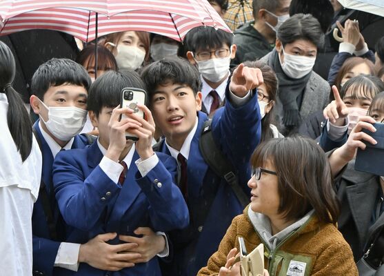 掲示板で自分の受験番号を見つけ喜ぶ中学生たち＝12日午前10時、宇都宮市岩曽町