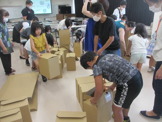 段ボールベッドの組み立てを体験する参加者たち