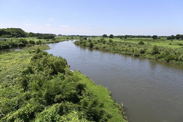 兄弟が投げ込まれ殺害された思川の事件現場周辺。左岸堤防上には供養のための地蔵２体が設置されている＝８月下旬、小山市内