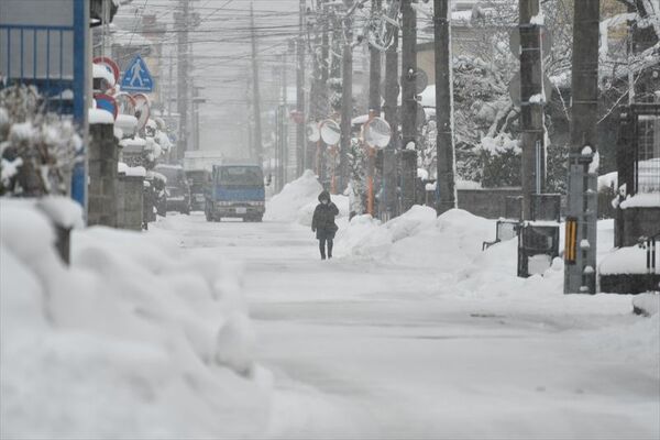 一斉除雪後の秋田市泉中央の市道。道路脇には雪山が残る＝２０２３年12月22日午後２時55分ごろ