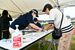 会期前競技の入場口で体調管理チェックシートを確認する係員（左）。国体・障スポ各会場で感染対策が取られた＝９月10日午前、足利市内