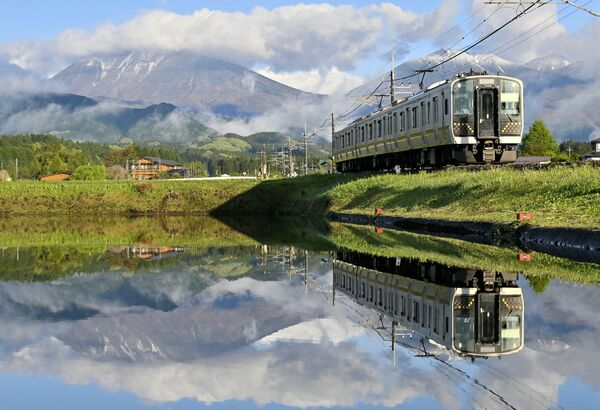 日光連山や列車が映り込んだ水田=29日午前6時5分、日光市和泉