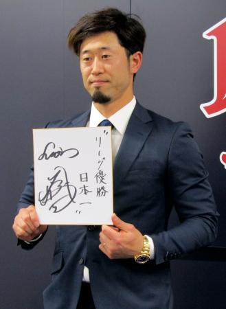 　契約更改交渉を終え、来季の抱負を記した色紙を掲げる西武・外崎＝５日、埼玉県所沢市