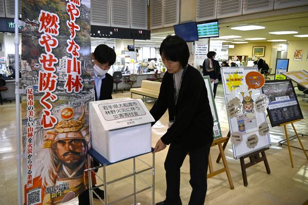 足利市役所市民ホールに募金箱を設置する同市職員＝４日午後２時50分
