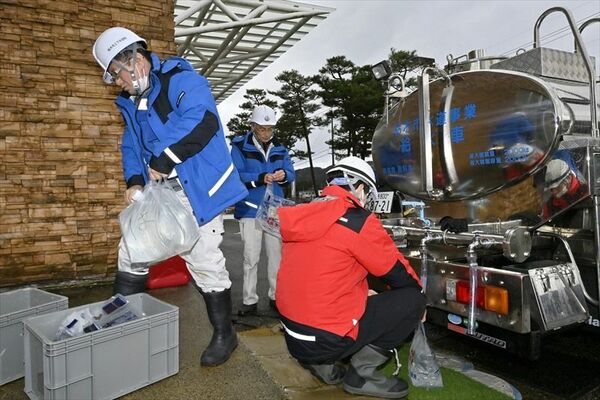 給水車から袋に水を入れる栃木市職員たち＝１日午前10時45分、輪島市門前町深田