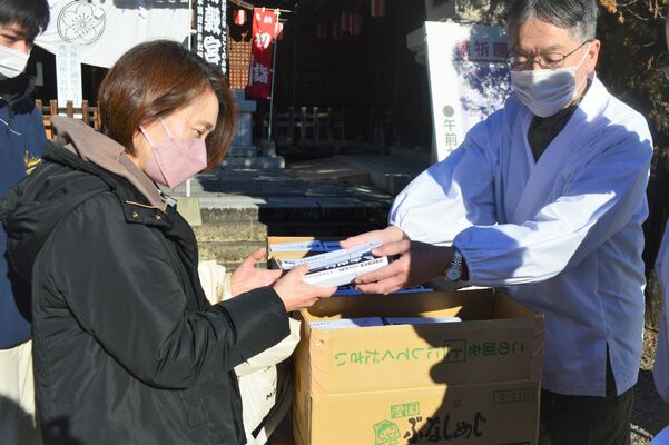 年越しそばを受け取る参拝者＝31日午前、宇都宮市陽西町