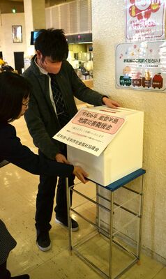足利市役所１階に募金箱を設置する職員