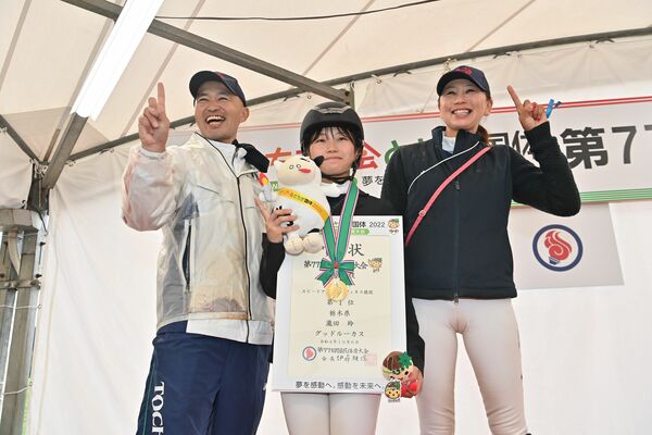 馬術１日目の競技で３人そろって優勝し、「１」のポーズを決める瀧田玲（中央）と広田龍馬（左）、思乃夫妻＝６日午後２時半、那須塩原市の地方競馬教養センター