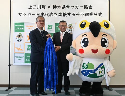 星野会長（左）に千羽鶴を手渡す星野町長＝11日午前、宇都宮市鶴田２丁目